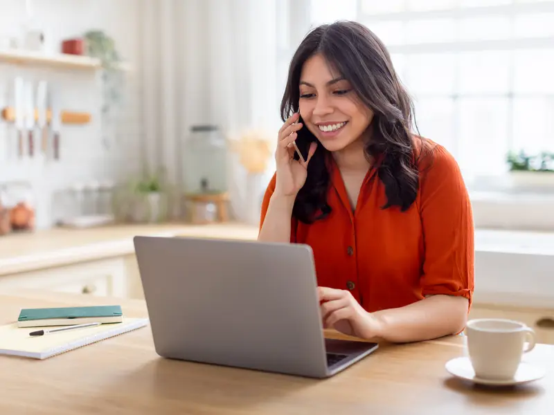The image depicts a smiling woman on the phone.